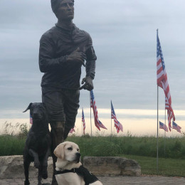 yellow lab standing next to Jon Tumilson statue 